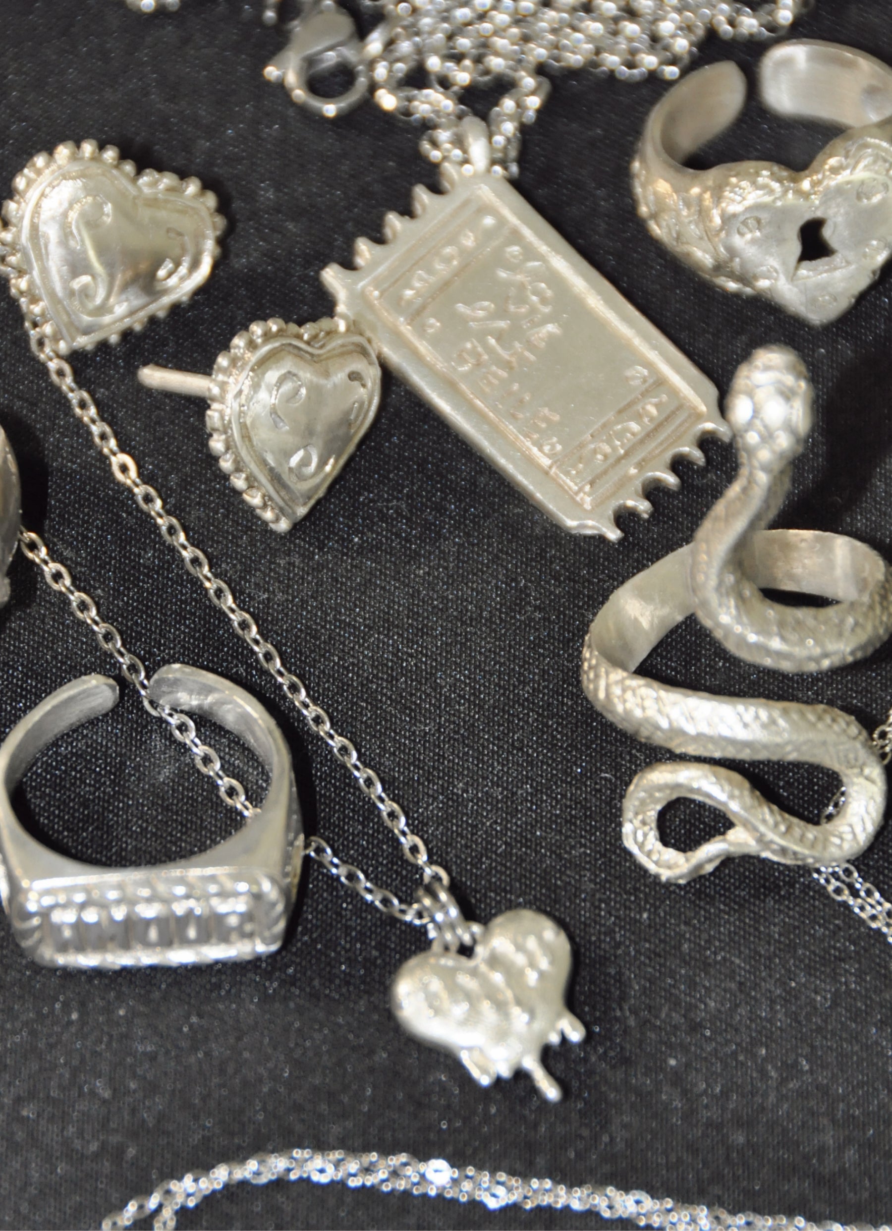 Diferentes joyas de plata como anillos pendientes y collares en una sola foto